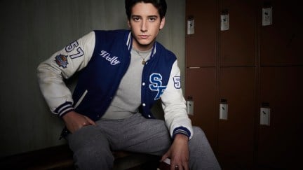 Milo Manheim as Wally in School Spirits, posing in front of a wall of lockers.