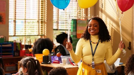 Quinta Brunson as Janine Teagues in Abbott Elementary holding balloons in the classroom