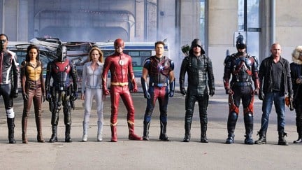 The cast of an Arrowverse Crossover, lined up in a row, includes characters like Mr. Terrific, Sarah Lance, The Flash, Arrow, The Atom and Captain Cold