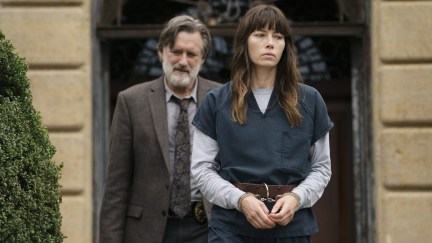 A white woman being escorted out of a court in chains with a white man in a suit behind her.