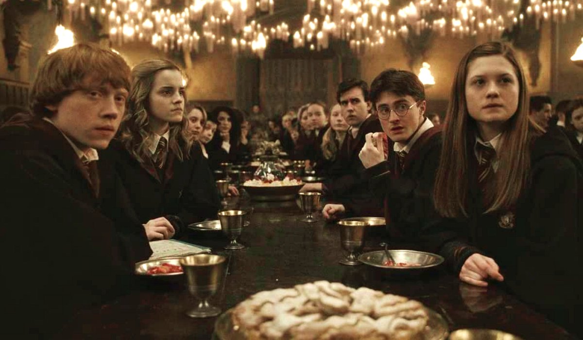 Ron, Hermione, Harry and Ginny sitting at a table (Warner Bros.)