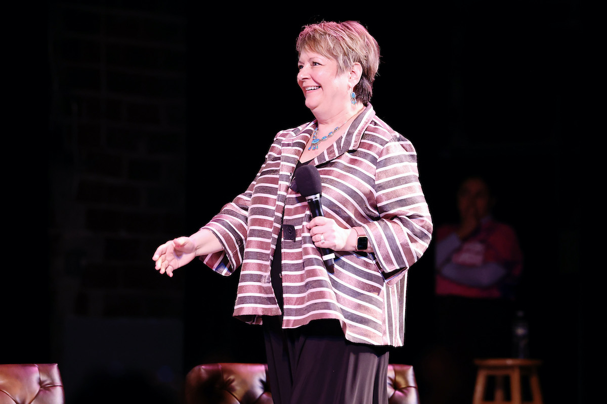 Judge Janet Protasiewicz walks across a stage holding a microphone.