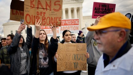 Abortion rights protesters hold signs during a demonstration.