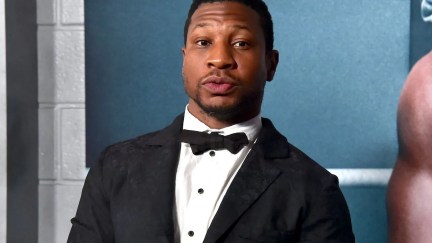 Jonathan Majors looks into the camera, wearing a tuxedo