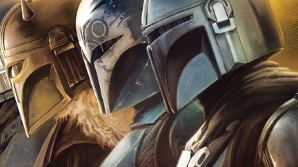 Cropped image of The Armorer (Emily Swallow), Bo-Katan (Katee Sackhoff), and Din Djarin (Pedro Pascal) standing in a row suited up in their Mandalorian helmets in a poster for 'The Mandalorian' on Disney+.