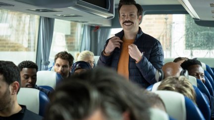 Ted stands on the team bus, with all the Richmond players in their seats.