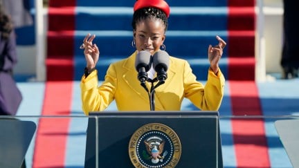 Amanda Gorman speaks from a podium bearing the US presidential seal.