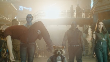 The Guardians of the Galaxy walk toward the camera. Nebula is carrying Peter in her arms.