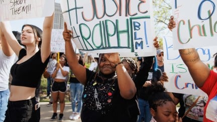 Protesters hold signs in support of Ralph Yarl.