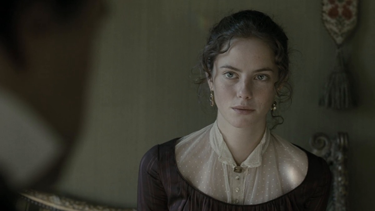 A young woman gazes cautiously at an offscreen person in "Wuthering Heights"