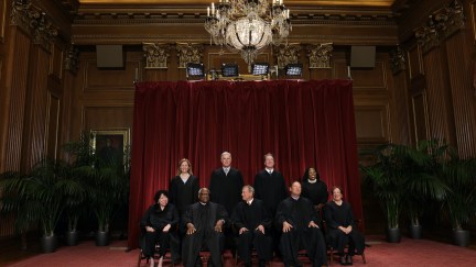 A zoomed-out photo of the Justices of the Supreme Court posing together for a portrait.