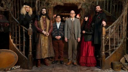 The cast of What We Do in the Shadows stands in the foyer of their mansion.