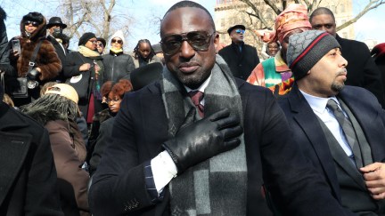 Yuself Salaam at an event, puts his hand over his heart and looks into the camera.