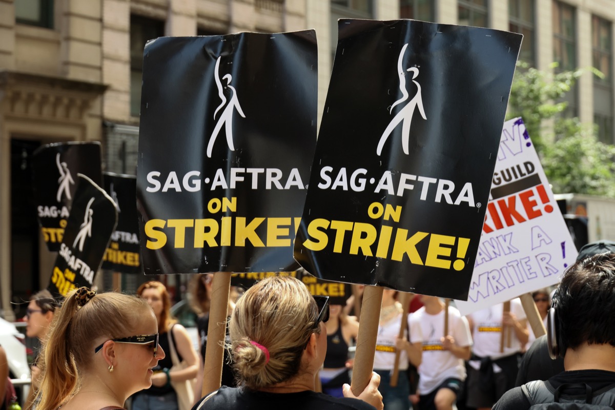 NEW YORK, NEW YORK - JULY 21: SAG-AFTRA members walk the picket line outside of Netflix and Warner Bros on July 21, 2023 in New York City. Members of SAG-AFTRA, Hollywood's largest union which represents actors and other media professionals, have joined striking WGA (Writers Guild of America) workers in the first joint walkout against the studios since 1960. The strike could shut down Hollywood productions completely with writers in the third month of their strike against the Hollywood studios. (Photo by Dia Dipasupil/Getty Images)