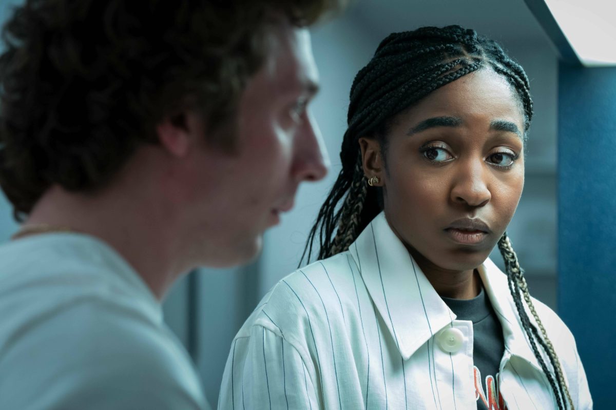 A Black woman with a worried look on her face reacts to a conversation she is having.