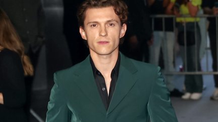 Tom Holland in a green suit at a movie premiere.