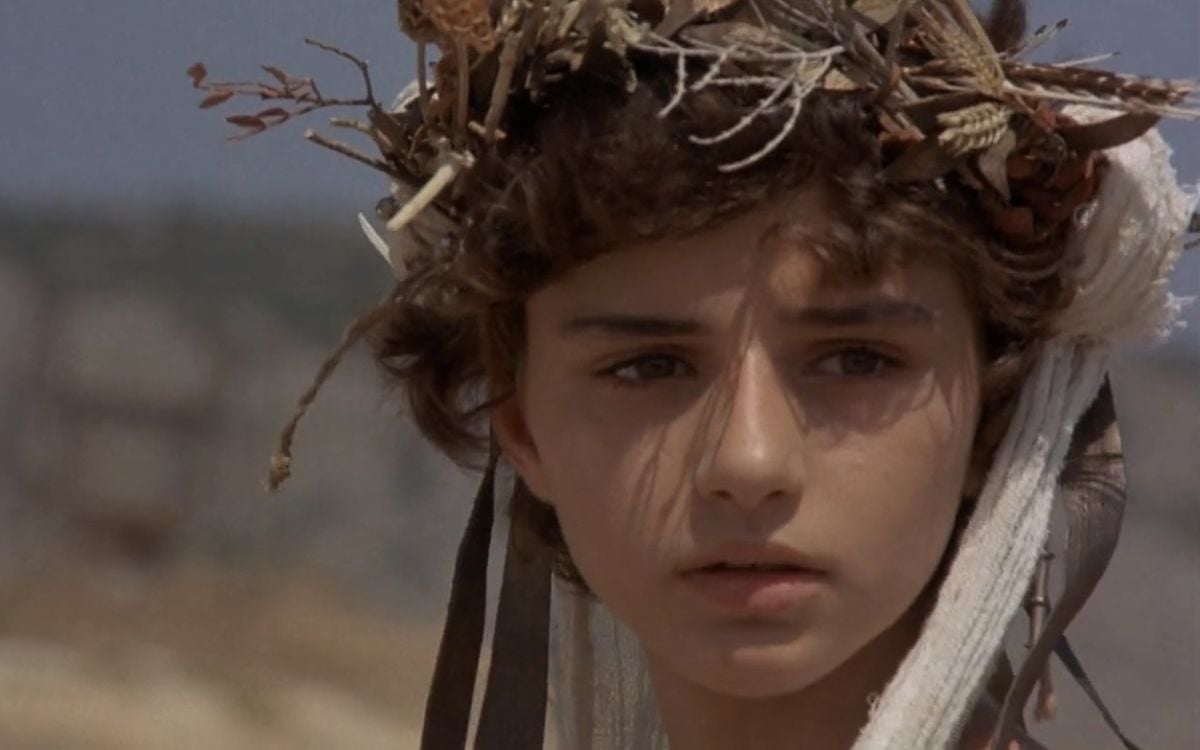 A small child wearing a flower crown in the film "Iphigenia" 