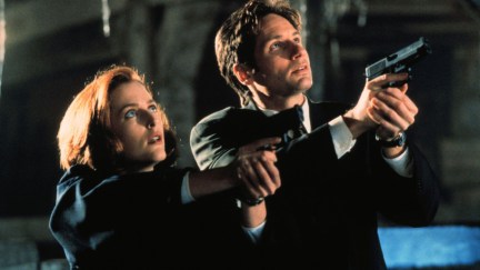 Agents Dana Scully (Gillian Anderson) and Fox Mulder (David Duchovny) in 'The X-Files': A woman and a man stand with guns pointed upward at an unseen target.