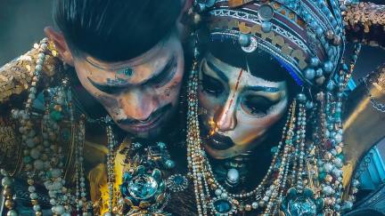 Two people dripping in jewels and gold dance sensually in 