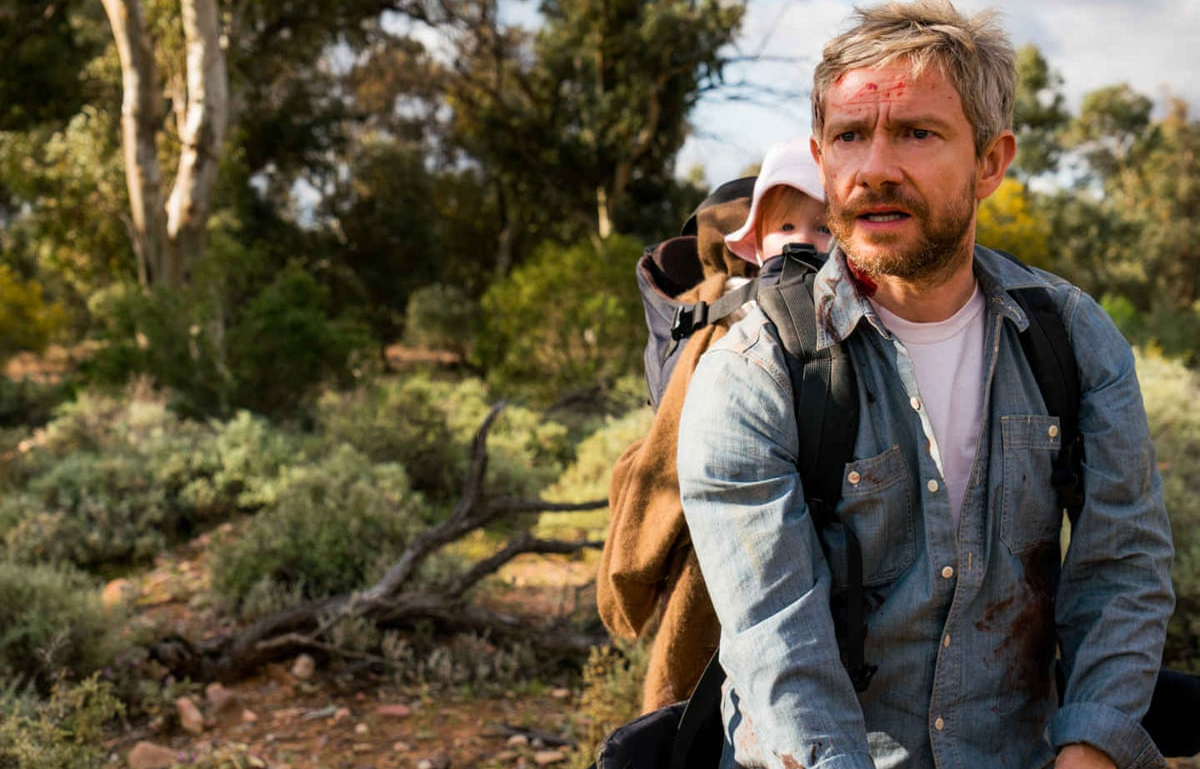 Martin Freeman in 2017's 'Cargo': A man carries a baby on his back in a wooded area. There is blood on his face and hands.