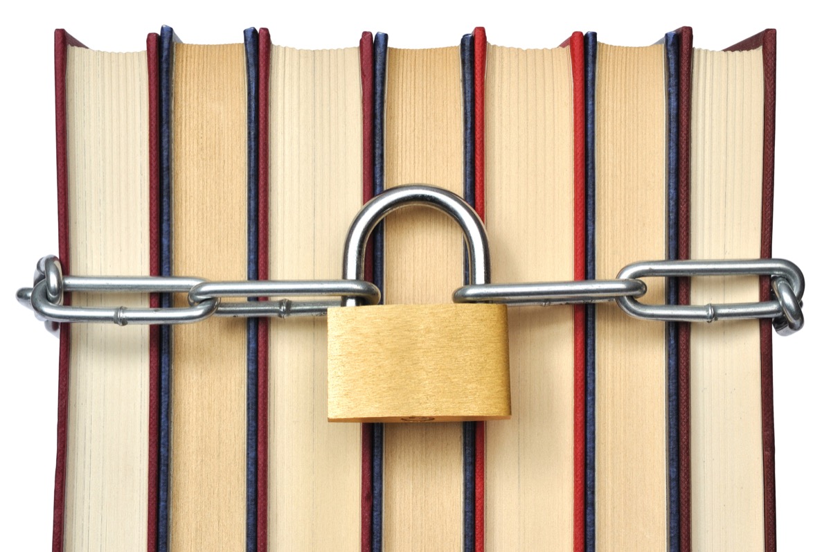 A group of books with a chain around them, with a large padlock in the middle.