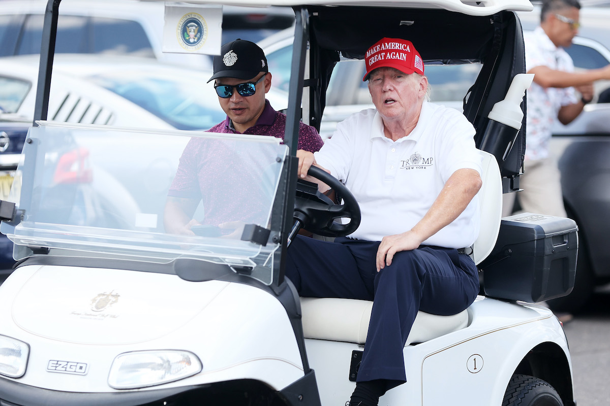 Donald Trump drives a golf cart.