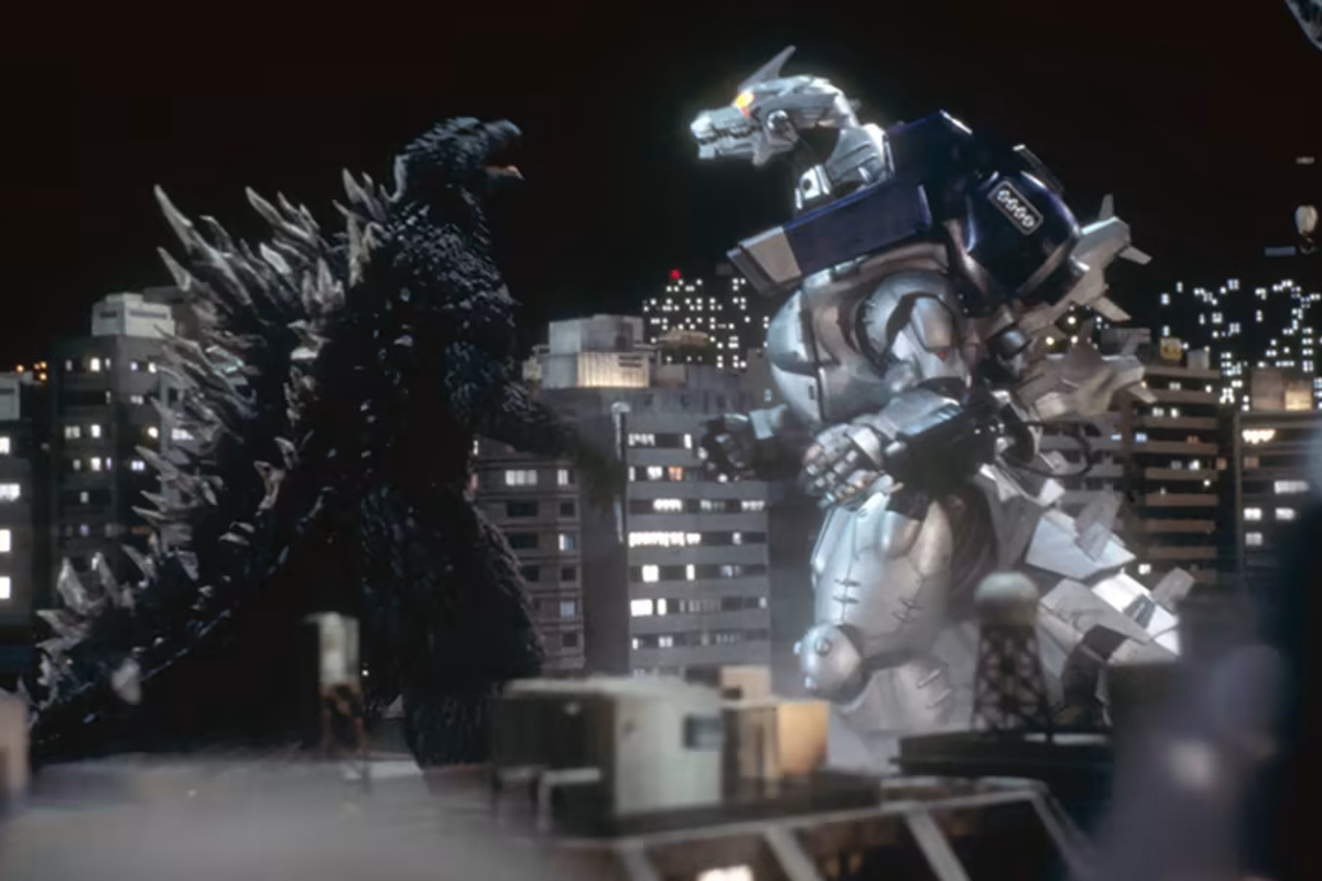 Still from Godzilla vs Mechagodzilla 3; Godzilla fights Mechagodzillah in front of a tower block at night.