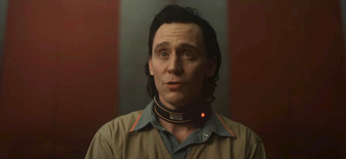 Loki looks worried as he speaks, wearing his TVA prisoner's jumpsuit and a time collar in the Loki season 2 trailer.