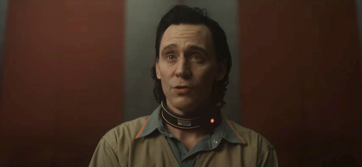 Loki looks worried as he speaks, wearing his TVA prisoner's jumpsuit and a time collar in the Loki season 2 trailer.