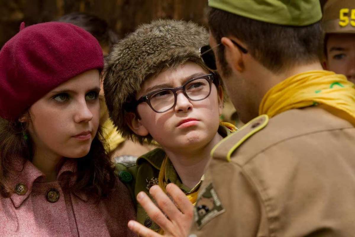 Suzy and Sam from Moonrise Kingdom looking perturbed by something a scout master is saying to them