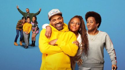 A Black family of 7 smiling at the camera from the the sitcom 'The Upshaws