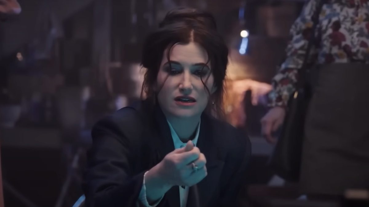 Kathryn Hahn as Agatha Harkness, examining something in her hand.