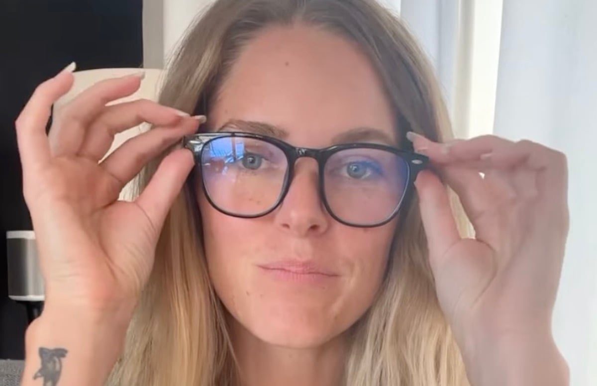 Influencer Samantha Lotus grabbing the corners of glasses on her face.