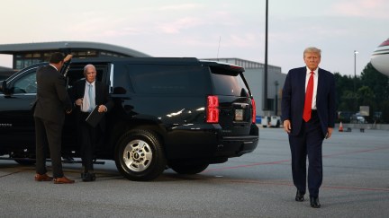 Donald Trump walks alone on an airport tarmac.