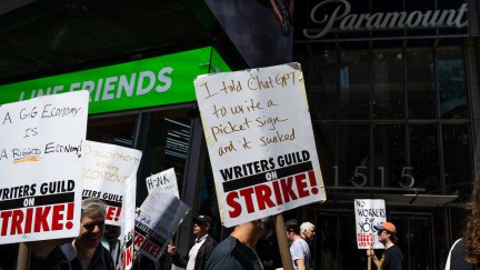 NEW YORK, NEW YORK - MAY 17: Writers Guild of America (WGA) East members walk a picket line at the Paramount+ Summit outside the Paramount Building in Times Square on May 17, 2023 in New York City. As the strike enters its third week the WGA East members picketed at events centered around New York Upfront week, a decades-old tradition where media companies stage lavish events to promote their new programming lineups in an attempt to woo advertisers. Union members have stated that they are not being paid fairly in the streaming era and are seeking pay increases and structural changes to the business model. Many are also concerned about the effects of AI across the industry. (Photo by Alexi Rosenfeld/Getty Images)