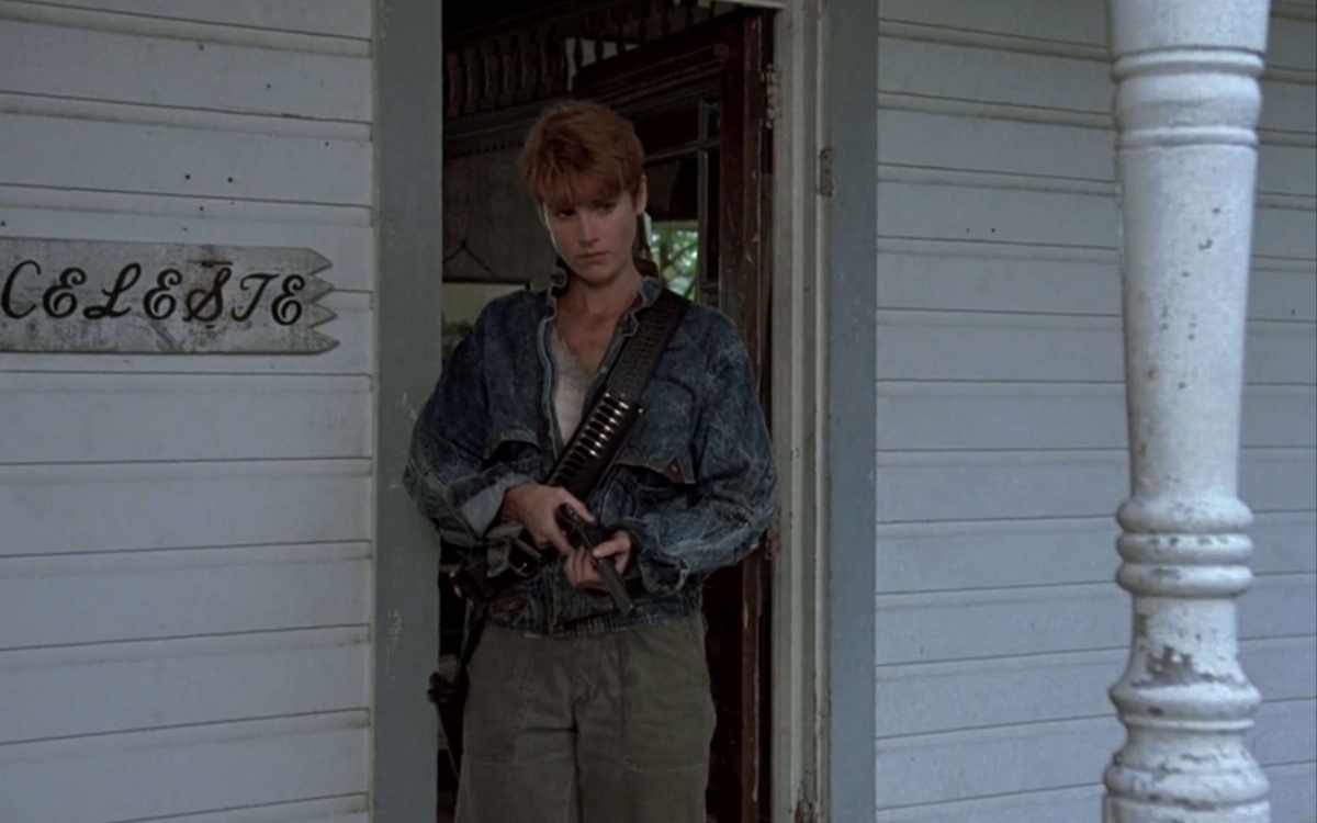 Patricia Tallman as Barbara Todd in Tom Savini's 1990 remake of Night of the Living Dead. A red-haired caucasian woman stands on the porch of a white farm house holding a shot gun.