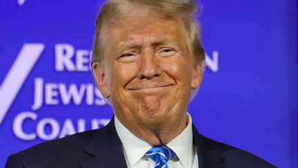 Trump head and shoulders, weird smile, against blue background