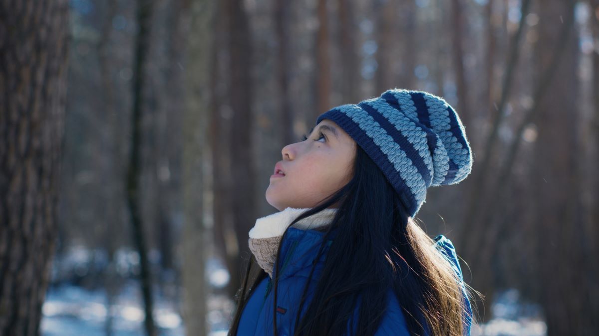 Hana gazing up at the trees in 'Evil Does Not Exist'.