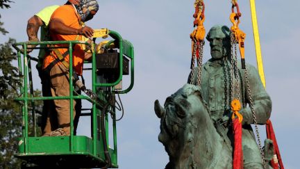 Workers remove a statue of Confederate General Robert E. Lee in Charlottesville, Virginia