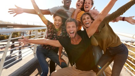 A group of young adults poses enthusiastically for a photo.