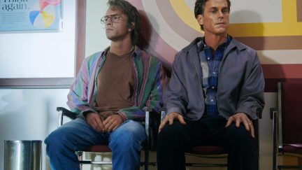 Two men (Jonathan Bailey and Matt Bomer) sit in an AIDS clinic waiting room in 'Fellow Travelers.'