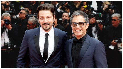 Diego Luna, a man with in a black suit, stands next to Gael García Bernal, in a dark suit wearing sunglasses.