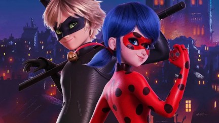 Miraculous Ladybug and Chat Noir stand back to back against a cityscape in 