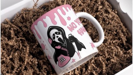 A white mug with pink blood spatter and the ghost face killer in black and white on it. The test 