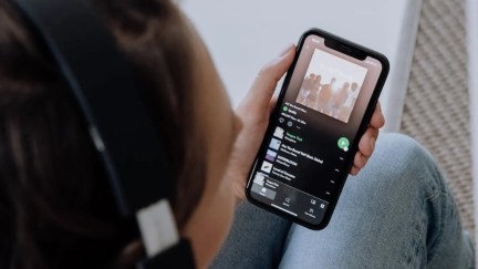 A person listens to Spotify music on their phone