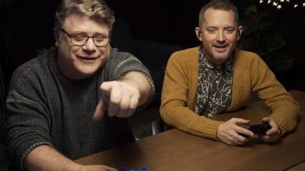 Sean Astin pointing at what Elijah Wood while they and Swen Vincke play the first act of Baldur's Gate 3.'