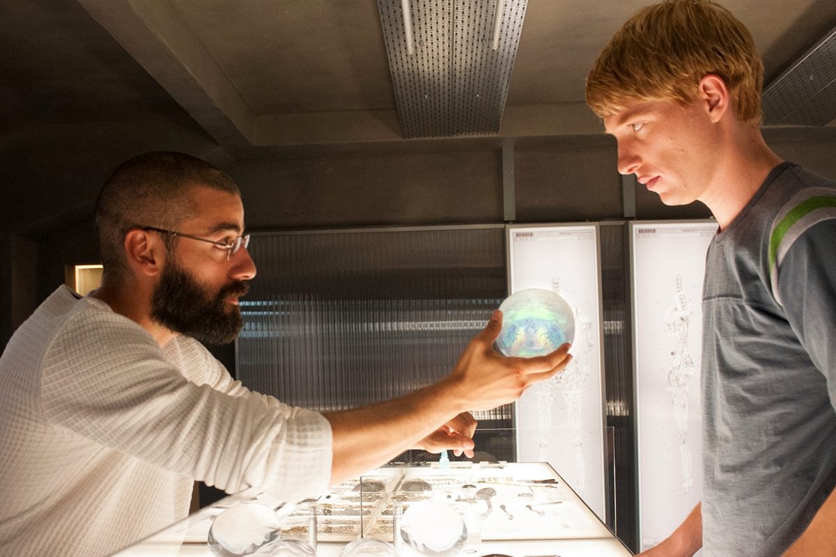 A man hands another man an artificial intelligence brain in 'Ex Machina.'