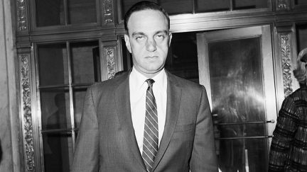 Roy Cohn outside of a courthouse in a black and white photo.