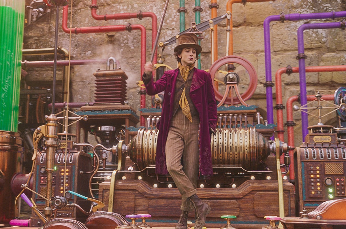 Timothée Chalamet as Willy Wonka standing in his building chocolate factory