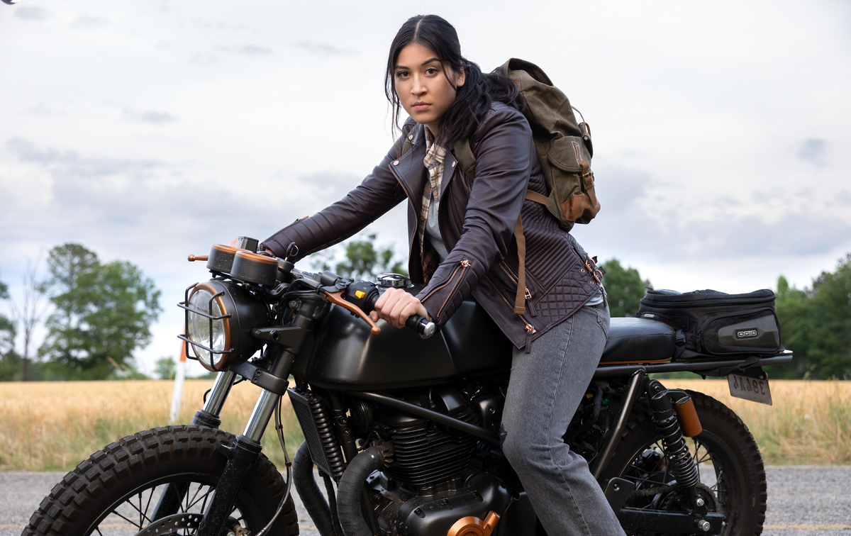 Maya Lopez sits on her motorcycle on a country road.